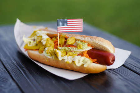 American patriotic hot dog on wooden board with USA flag. Celebrating Independence day on 4th July in United States of Americaの写真素材