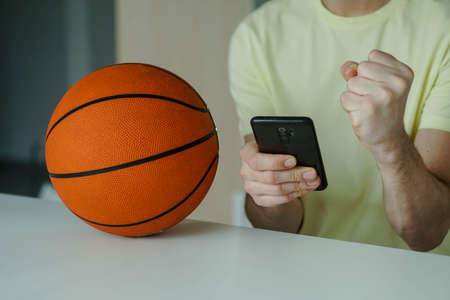Close up of happy young man celebrate winning of his basketball bet. Concept of betting, gambling.の写真素材