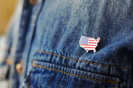 United State of America pin is pinned on blue jeans jacket. USA patriotism concept.の写真素材