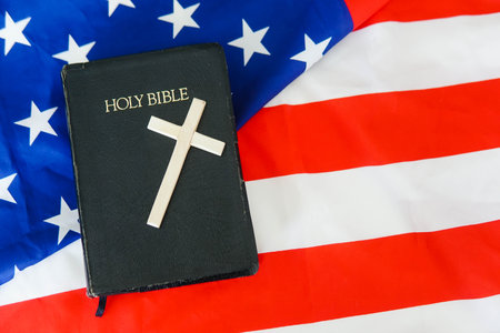 Old Holy Bible with a cross on american flag. Copy space.の写真素材