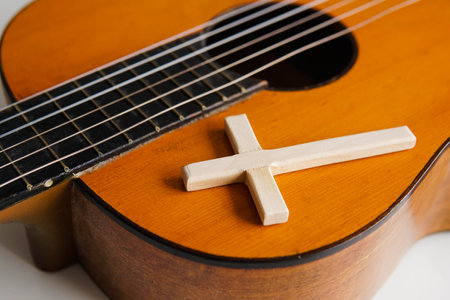 Acoustic guitar with wooden cross on the table close up. Christian music.の写真素材