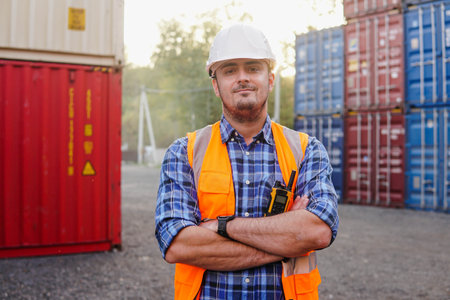 Portrait of smiling container man worker in container warehouse. Import and export shipping. Logistics management in container yard.の写真素材
