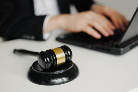 Judges gavel on the table. Lawyer using laptop on the background.