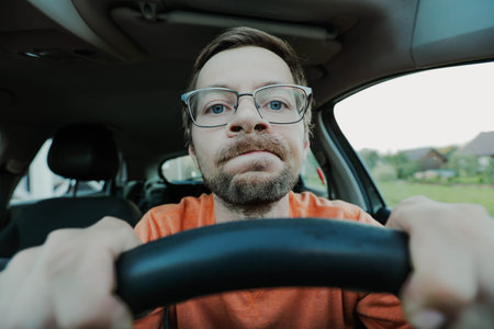 Young male novice driver in glasses looking at camera.の写真素材