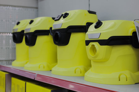 Row of variety yellow vacuum cleaners on a supermarket shelf.の写真素材