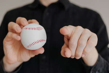 Man holding baseball and pointing his finger to the camera close upの写真素材