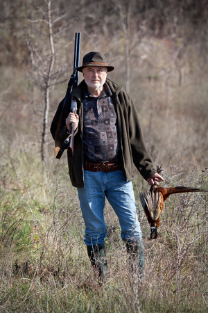 Hunter with a gun and wildfowl after a successful shotの写真素材
