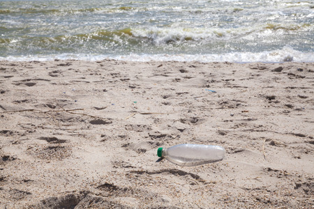 Used and thrown plastic bottle on the clean sea beach as garbageの写真素材