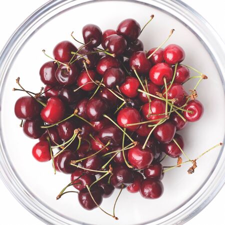 Fruits ripe juicy tasty red sweet cherry in a clear round bowl. Top view.の写真素材