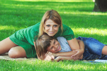Portrait of mother and son on a green lawnの写真素材