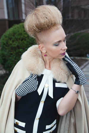 Elegant blond woman in retro style posing at autumn streetの写真素材