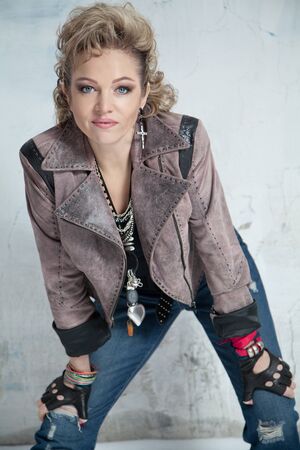 Beautiful blonde woman in rock style smiling and looking into the cameraの写真素材