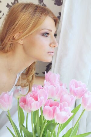 Portrait of a beautiful girl with pink tulipsの写真素材