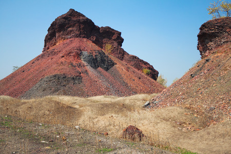 Landscape mine area with red waste piles against the blue skyの写真素材