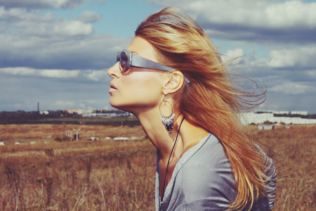 Profile of a beautiful woman in the urban landscape in glassesの写真素材