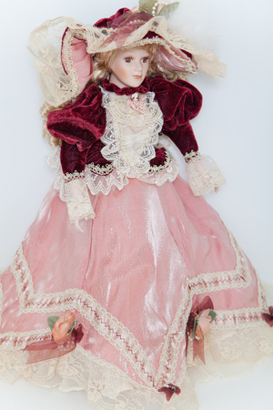 Doll lady in elegant velvet dress with a hat on white backgroundの写真素材