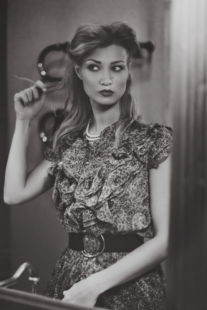 Monochrome image of a beautiful girl close-up in retro style in mirrorの写真素材