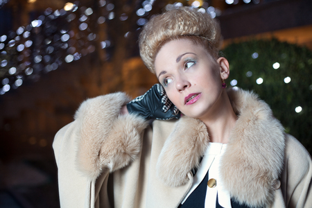 Elegant blond woman in retro style posing on the street in the evening autumnの写真素材