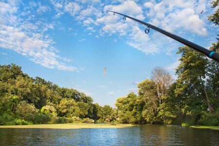 Tackle for fishing with spinning on river at summerの写真素材