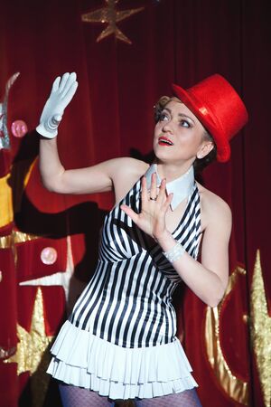 Circus artist woman magician raised her hands in frightの写真素材