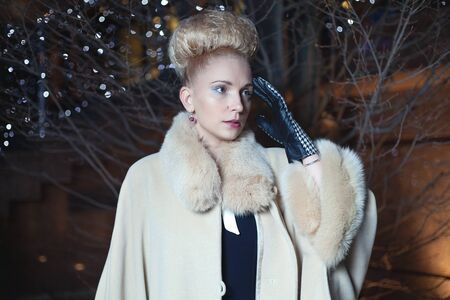 Elegant blond woman in retro style posing on the street in the evening autumnの写真素材