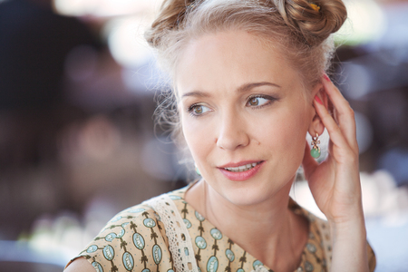 Portrait of a beautiful blonde girl in romantic retro dress on the street