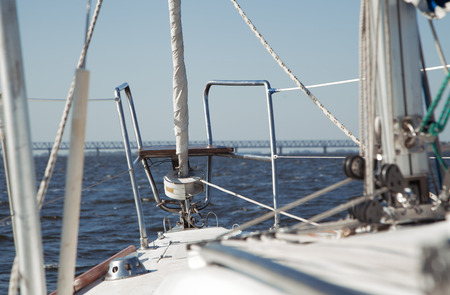 Rope and winch on a sailing vessel. View on deck of sailing yacht. Picture from perspective of sitting on deck of yachtの写真素材