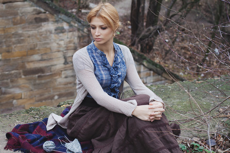 Portrait of beautiful girl knitting in vintage style on nature backgroundの写真素材