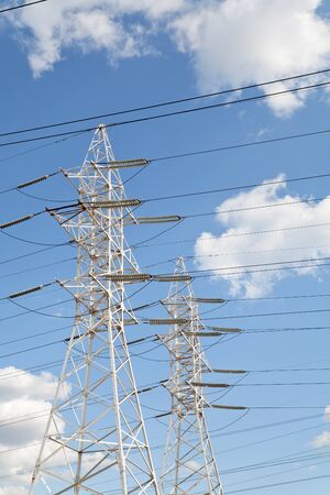 Power transmission high voltage lines on the white supports against blue skyの写真素材