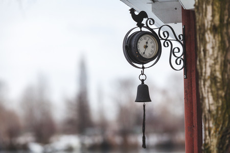 Beautiful street clock round shape fixed on a wooden postの写真素材