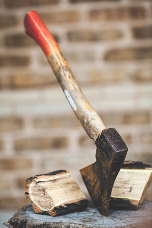 Hatchet sticking in a stump, the two halves of split logs are nextの写真素材