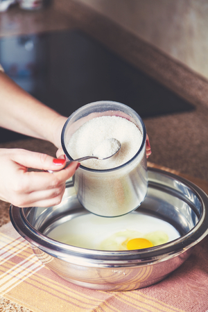 Ladies hand dials the sugar spoon from a transparent containerの写真素材