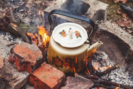 Sooty iron kettle is on the fire between the bricks. View from above
kettle, iron, fire, flame, smoky, brick, smoke, wood, fire, hearth, heat, warmth, nature, picnic, rest, hot water, tea, hot, water, cover, handle, spout, cold, warming, drink, appetite, の写真素材