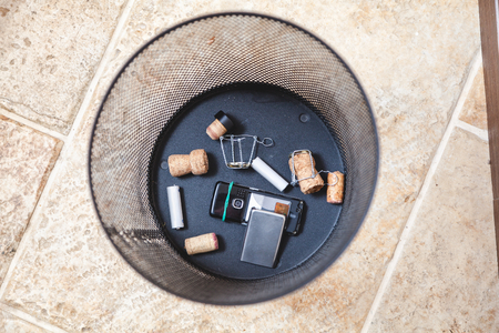 Corks of sparkling wine and muzzle lie on the bottom of the wastebasket. Nearby is a broken cell phone
の写真素材