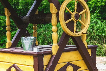 Yellow wooden wheel acting on the collar of the well and pail
の写真素材