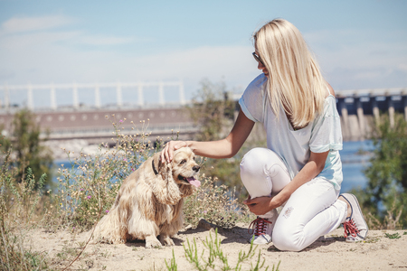 Blonde With Long Hair Irons Cocker Spaniel On A Hot Summer Day