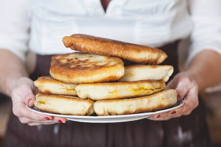 Appetizing fried patties stacked high on a plate in female hands closeupの写真素材