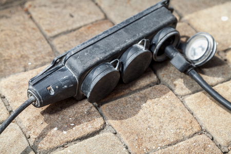 Industrial Extension unit into three outlet lying on its side on the stone square tilesの写真素材