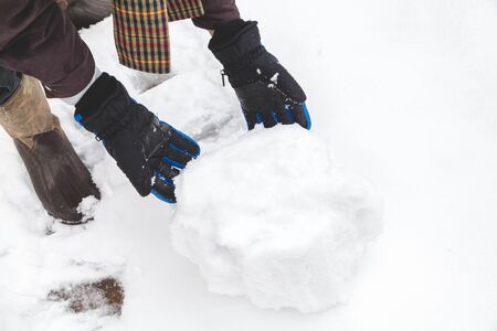 Hands in the ski gloves creates a snowball winter day