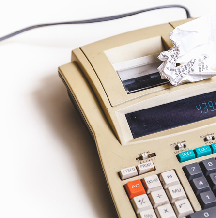 Crumpled paper check lies on the printing calculatorの写真素材