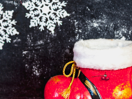 Winter still life. Red Santa Claus boot and beautiful white snowflakes on a dark background
の写真素材