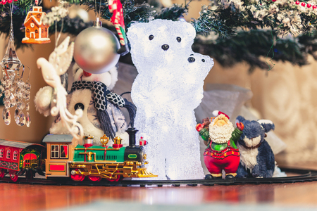 Toys under the Christmas tree glowing figure of a polar bear with a bear stand in front of a decorated Christmas tree. Near Santa Claus
の写真素材