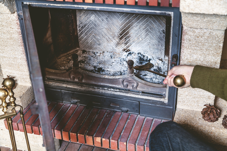 Cleaning the fireplace. Hand of man holding a brass shovel with ash
の写真素材