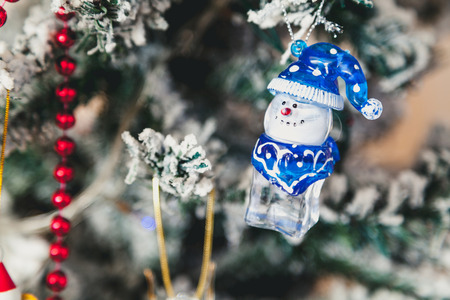 Original Christmas-tree toy a glass figure of a snowman with a blue cap weighs on a Christmas tree.
の写真素材