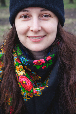 Portrait of a pretty girl with long red hair in a scarf traditional Russian colors on the neck in a spring park closeup
の写真素材