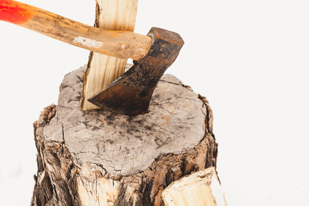 Felling firewood in winter. The ax is sticking out in a stump on a nearby split log. Near the second log is sticking out in the snowの写真素材