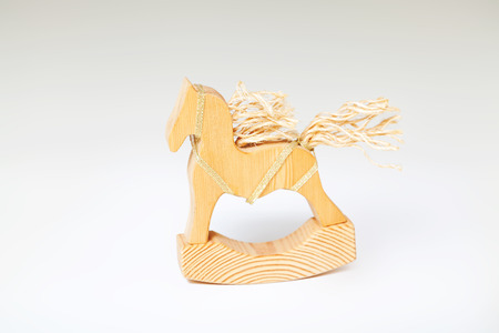 Wooden toy rocking. Figurine of a horse with a mane and tail of ropes on a white backgroundの写真素材