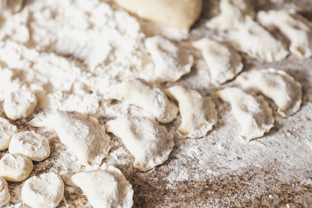 Some raw dumplings lie on a marble table top in white flourの写真素材