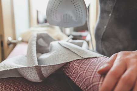 Handmade. Smoothing the wide seam of the garment on a special narrow fitting with a modern iron
の写真素材