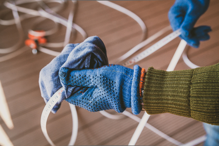 Care of the tool. Hands in blue gloves wipe with a rag metal tape long measuring rouletteの写真素材
